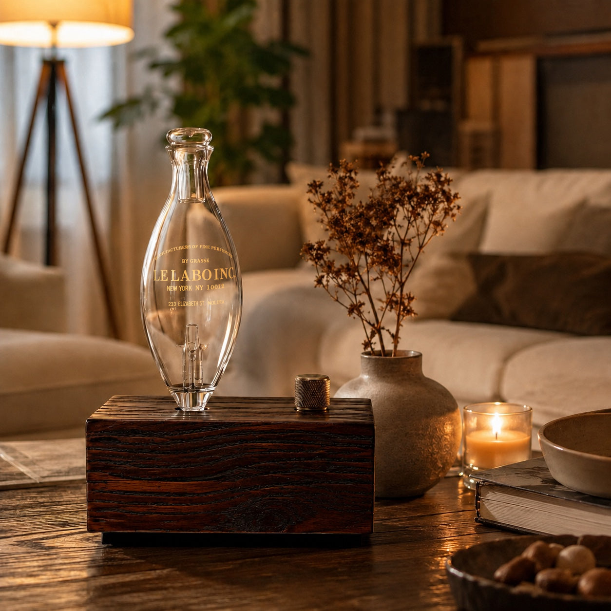 Wooden diffuser arranged with books and a ceramic vase on a coffee table